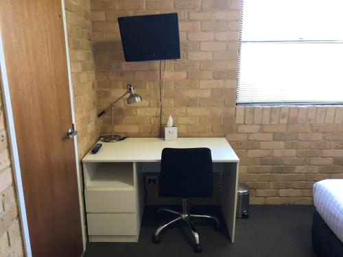 a desk with a computer and a chair in a room at Hanbury Lodge in Newcastle