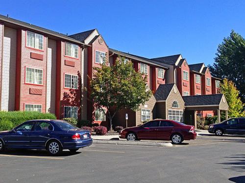 two cars parked in a parking lot in front of a building at Motel 6-Meridian, ID - Boise W in Meridian