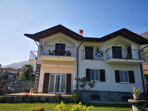 ein großes weißes Haus mit Balkon darauf in der Unterkunft VILLA AS Campo Marzio in Lenno