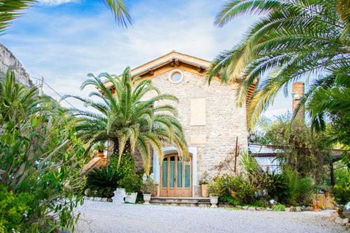 een stenen huis met palmbomen ervoor bij Agriturismo Paradiso Di Barchi in Terracina