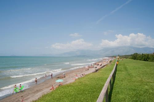 una folla di persone su una spiaggia con l'oceano di Happy Camp mobile homes in Villaggio Camping Baia Domizia a Baia Domizia