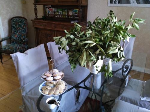 a glass table with donuts and a potted plant at Villa Giselle in Hayange