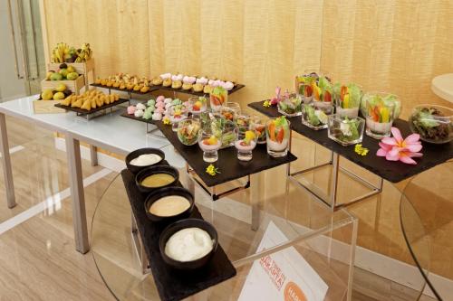 a table with many different types of food on it at HARRIS Hotel and Conventions Kelapa Gading Jakarta in Jakarta