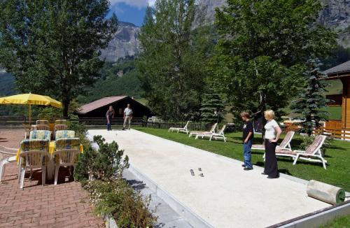 zwei Kinder spielen eine Partie Domino im Garten in der Unterkunft Alfa Appartements Superior in Leukerbad