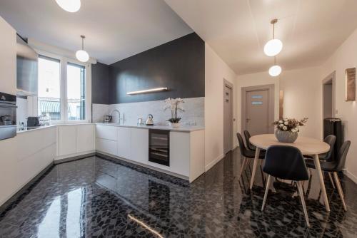 a kitchen with white cabinets and a table with chairs at Milan Royal Suites - Centro in Milan