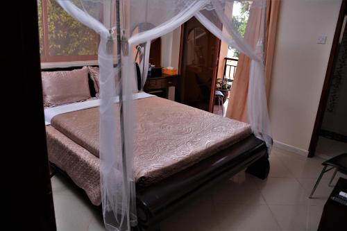 um quarto com uma cama de dossel em The Palms Beach Hotel em Entebbe