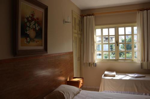 a bedroom with a bed and a window at Pousada Portal do Mar in Cabo Frio