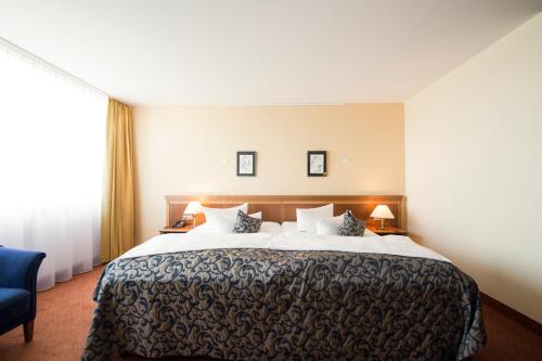 Giường trong phòng chung tại Carathotel Basel/Weil am Rhein