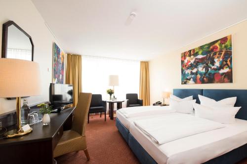 Giường trong phòng chung tại Carathotel Basel/Weil am Rhein