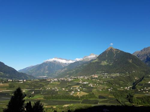 uma aldeia num vale com montanhas ao fundo em Appartment Maria em Schenna