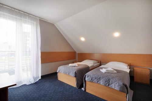 a hotel room with two beds and a window at Hotel Wena in Kielce