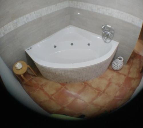 e bagno con vasca e pavimento piastrellato. di Escapadas romanticas en Granada jacuzzi a Granada