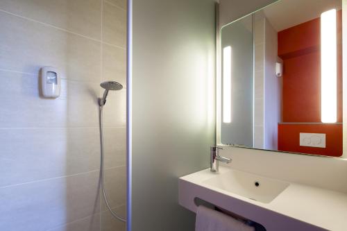 bagno con doccia, lavandino e specchio di B&B HOTEL Orly Chevilly Marché International a Chevilly-Larue