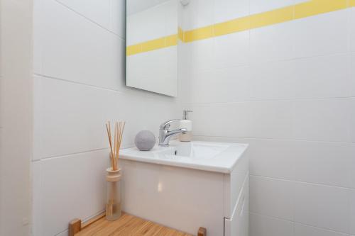 a white bathroom with a sink and a mirror at MouraLua in Sintra