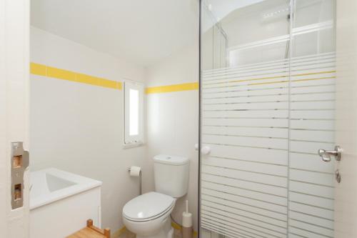 a white bathroom with a toilet and a sink at MouraLua in Sintra