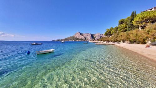 - une vue sur une plage avec des bateaux dans l'eau dans l'établissement Apartments Neda, à Omiš