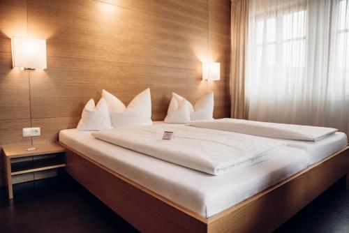 a bedroom with a large bed with white pillows at Landgasthof Zehner in Drosendorf