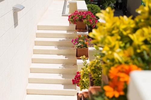 a stairway with flowers and potted plants on it at Villa King Apartments in Brela