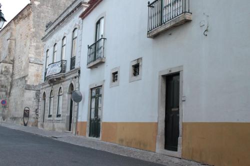 un edificio bianco con balconi sul lato di una strada di Casa do Arco, Santarém a Santarém