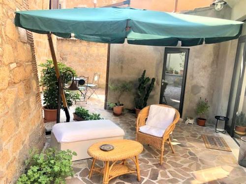 un patio con tavolo e ombrellone blu di INDUSTRIAL CHIC HOUSE - Private parking a Orvieto