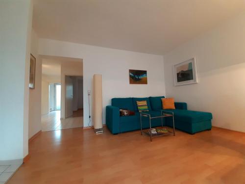 a living room with a blue couch and a table at Wohnung im Herzen von Ettlingen in Ettlingen