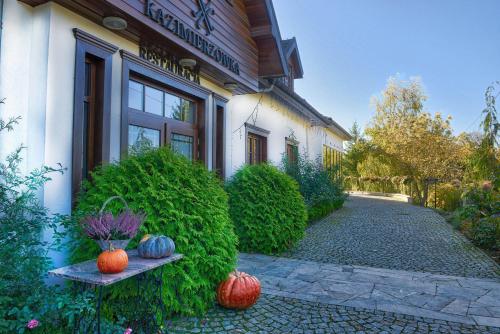 uma casa com abóboras sentadas num banco à sua frente em Hotel Kazimierzówka em Kazimierz Dolny