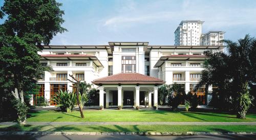 un grande edificio bianco con un prato di fronte di The Dharmawangsa Jakarta a Giacarta