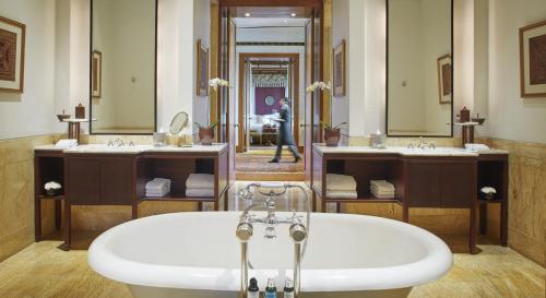 a bathroom with two sinks and a bath tub at The Dharmawangsa Jakarta in Jakarta