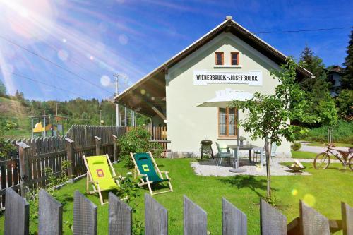 una piccola casa con sedie e recinzione di Urlaub am Bahnhof ad Annaberg