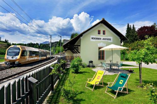 Un treno sta entrando in una stazione ferroviaria con delle sedie di Urlaub am Bahnhof ad Annaberg