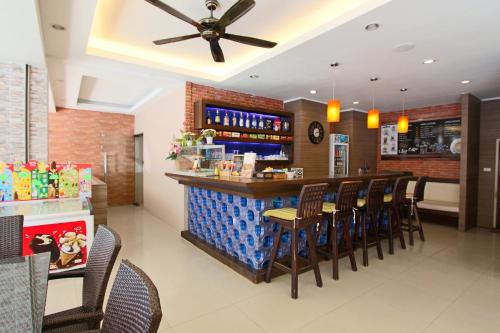 un ristorante con bar con sedie intorno di GN Capsule Hostel Patong a Patong Beach