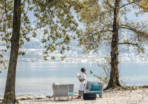 Una mujer parada en una playa cerca del agua en Castello del Sole Beach Resort&SPA, en Ascona