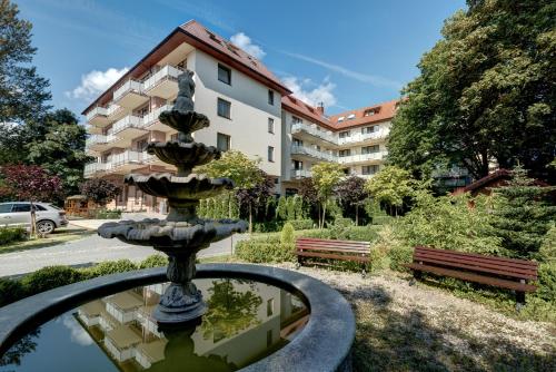 una fuente en un parque con un edificio al fondo en Olymp II, en Kołobrzeg