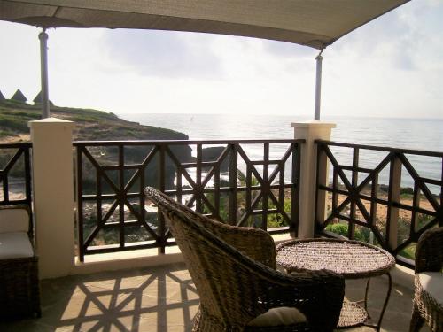 balkon ze stołem i krzesłami oraz widokiem na ocean w obiekcie Blue Bay Cove, Penthouse 4 w mieście Watamu