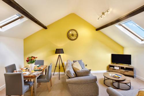 a living room with a table and chairs and a tv at The Old Sweet Factory in Harrogate