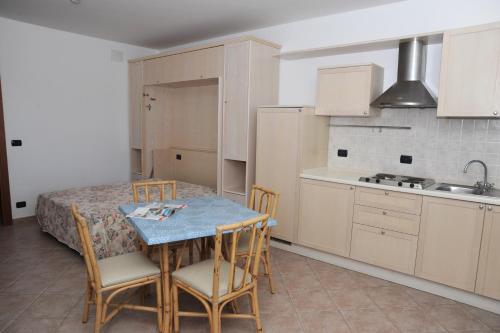 a kitchen with a table and chairs and a sink at Lo Smeraldo in Capoliveri