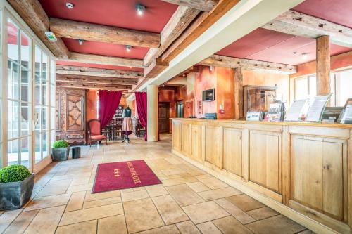 Großes Zimmer mit einer Bar mit Holzschränken in der Unterkunft Hôtel Du Théâtre Centre Historique Parking Souterrain Gratuit in Metz