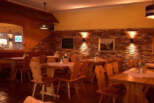 un ristorante con tavoli e sedie e un muro di mattoni di Beim Krahwirt a Deggendorf