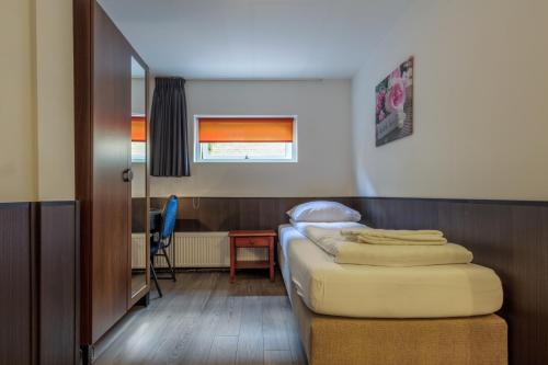 - une chambre avec un lit et un bureau avec une chaise dans l'établissement Hotel Randenbroek, à Amersfoort