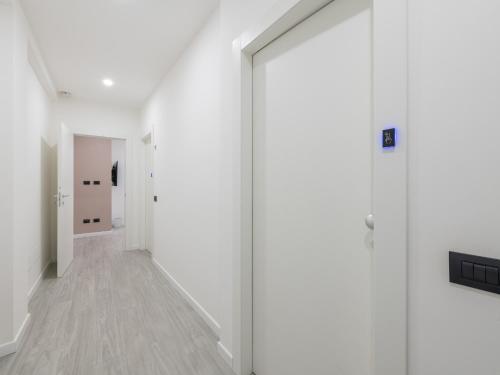 um corredor com paredes brancas e uma porta de vidro em Diaz Apartment em Cagliari