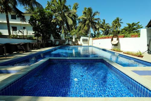 een zwembad met blauw water in een resort bij Calux Grand Baga - Formerly Amara Grand in Baga