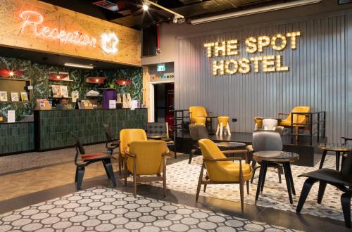 un restaurante con sillas y un cartel que lee el albergue en The Spot Hostel, en Tel Aviv