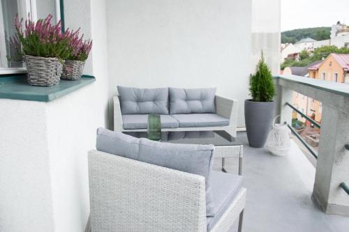 a balcony with a couch and a table and chairs at Hotel Krystal in Luhačovice