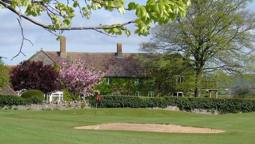 een golfbaan met een huis op de achtergrond bij Mendip Spring Golf and Country Club in Churchill