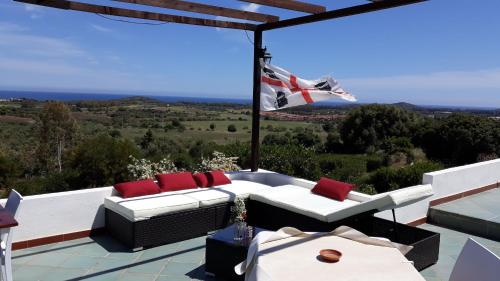 un patio con un sofá blanco y almohadas rojas en Villa delle torri, en Pula