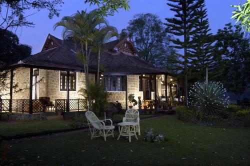 una casa con 2 sillas y una mesa en el patio en Lake Palace, en Thekkady