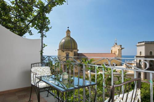 einen Balkon mit einem Glastisch und Stadtblick in der Unterkunft Hotel Palazzo Murat in Positano