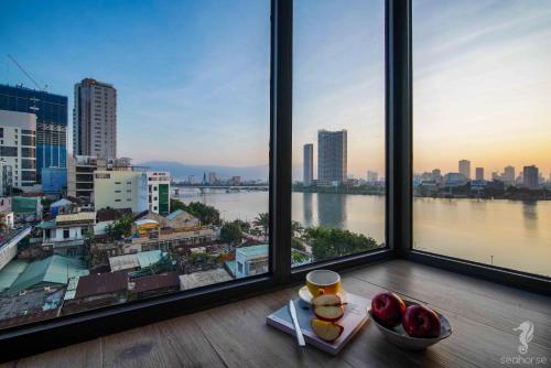 una ventana con vistas a la ciudad y un bol de fruta en Seahorse Han Market Da Nang Apartment by Haviland, en Da Nang