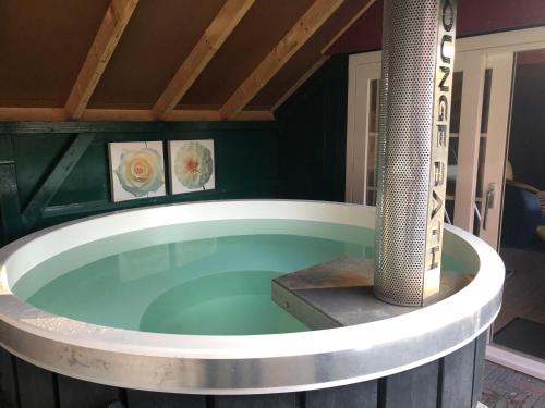 a jacuzzi tub in a house at De Lindenburg met privé hottub, sunshower, sauna, grote tuin met weidezicht en vrije ligging, 6-persoons in Lievelde