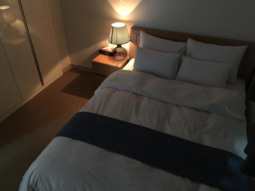 a bedroom with a bed with a lamp on a night stand at Hotel Joy near Camp Humphres in Pyeongtaek